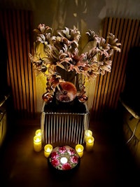 an arrangement of flowers and candles in a room