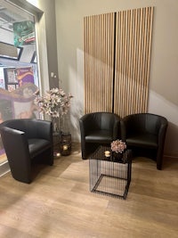 two black chairs in a room with a wooden wall