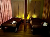 two massage beds in a room with curtains